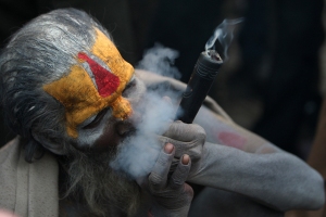 A Sadhu (Hindu holy man) smokes ganja (m